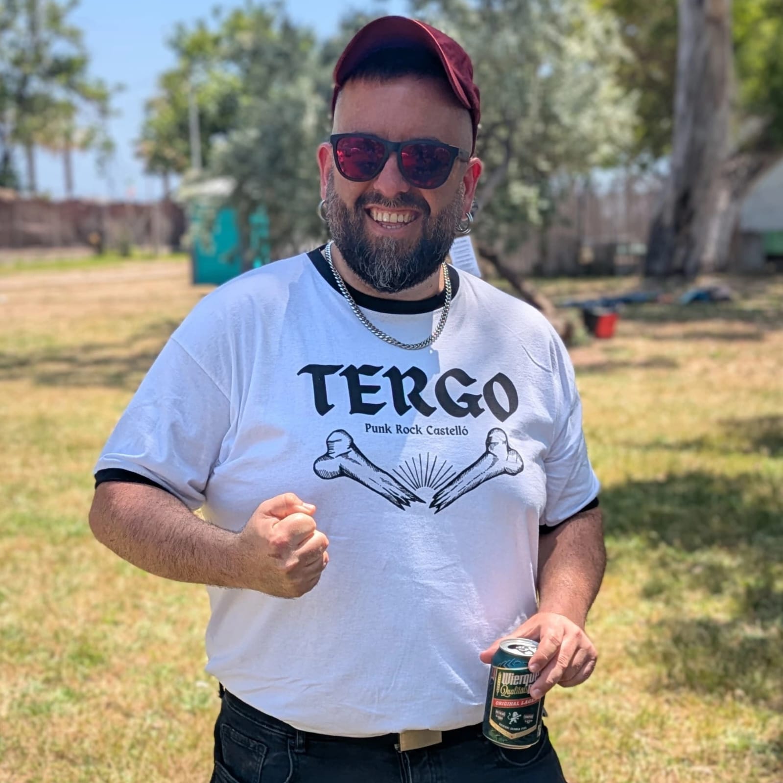 Foto de elPinya somrient amb una cervesa a la mà i el puny tancat